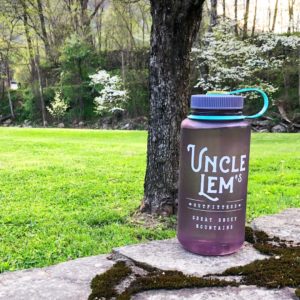 Uncle Lem's Nalgene in front of tree on a rock